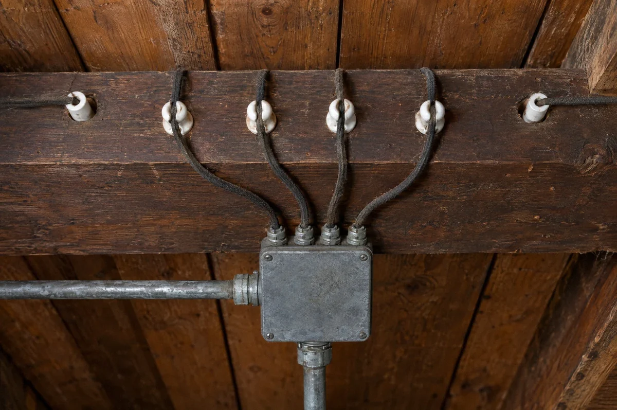 Illustration of older cloth-insulated wiring supported by porcelain fittings on wood framing