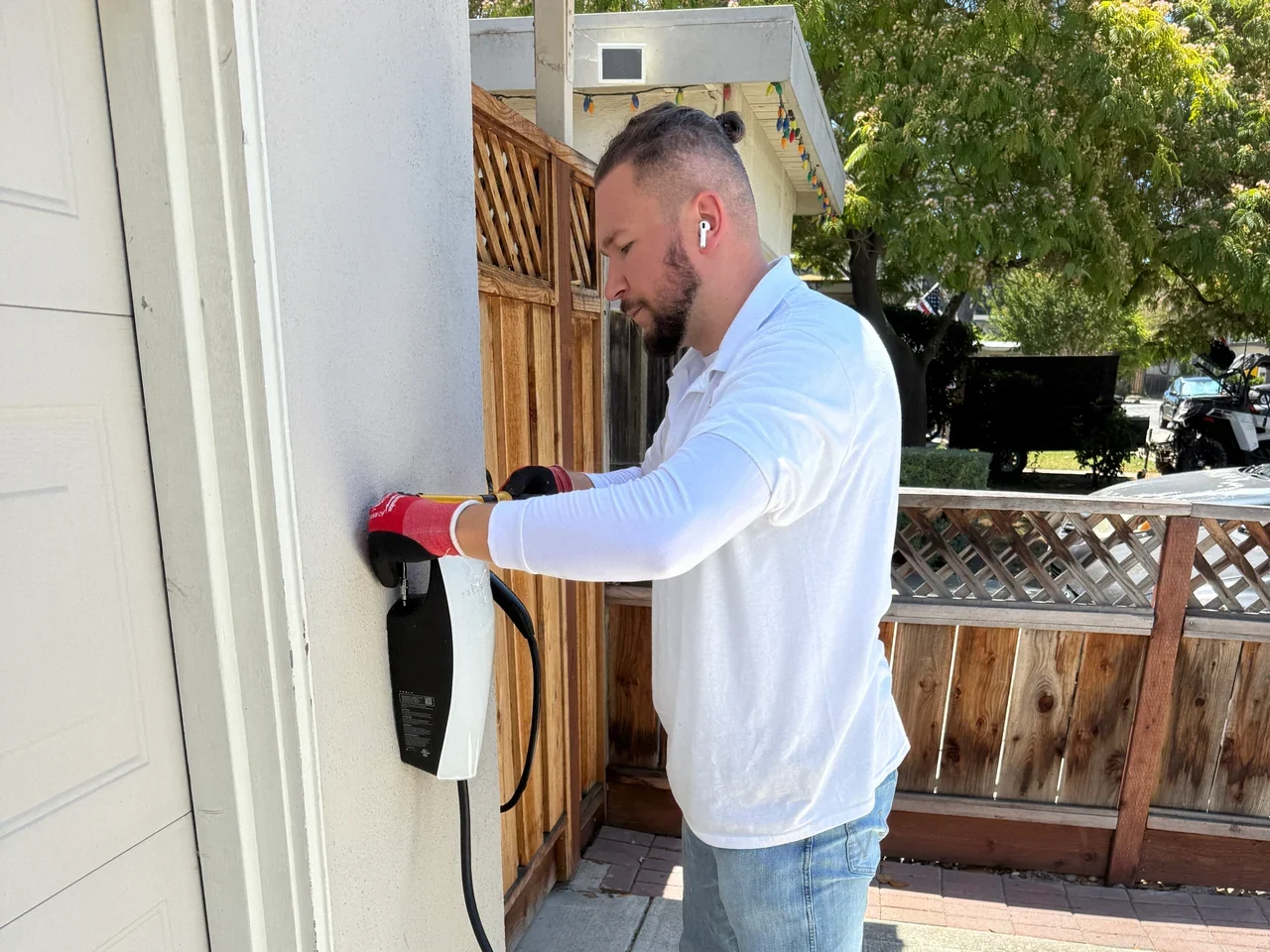 Technician working on a wall-mounted EV charging unit