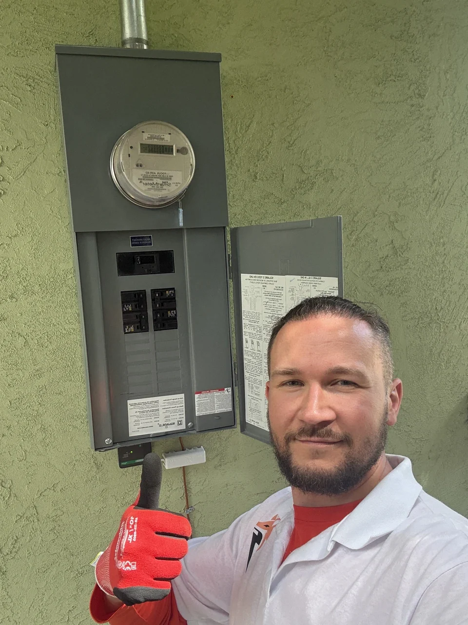 Fox Electric owner beside an outdoor meter and breaker panel