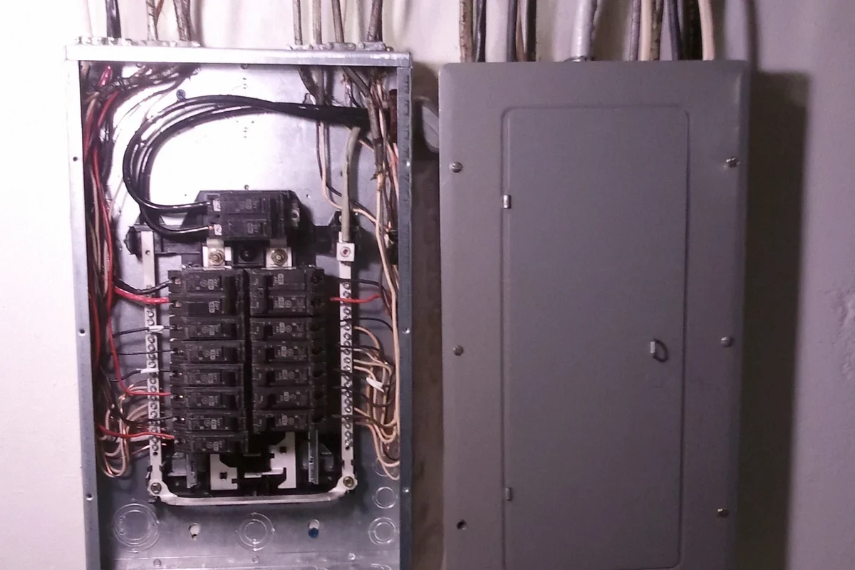 Reference photo of a residential main panel and subpanel, with the subpanel cover removed.